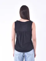 Musculosa blanca con cuello en V y sisas amplias.
