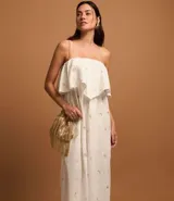 Vestido midi evasé sin mangas, confeccionado en tricolina color blanco, con escote recto con volantes y bordados metalizados de iconos.