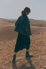 Vestido camisero midi negro con cuello camisero, botonadura frontal, mangas raglán cortas, elástico en la parte posterior de la cintura, frunces adelante y atrás, y cinturón extraíble para atar.