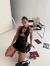 Minivestido negro con encaje, escote halter, espalda descubierta y aberturas en la cintura.