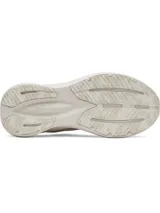 Zapatillas deportivas Under Armour modelo Assert 11 para mujer, color blanco hueso, con logo UA en el lateral. Presentan una suela gruesa con tecnología Charged+® y una combinación de malla transpirable y revestimientos de cuero sintético.