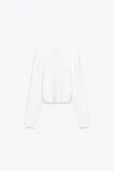 Chaqueta blanca de punto con cuello redondo y manga larga. Cierre frontal con botones con aplicación de joya.