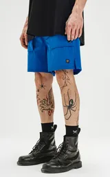 Bermuda azul francia de calce relax-fit, con bolsillos delanteros con fuelle, cintura con elástico y cordón de ajuste. Tejido Water Repellent de nylon y spandex.