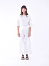 Blusa negra de mangas cortas con volados y escote redondo.