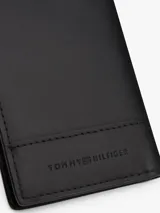 Billetera plegable de cuero negro con tres ranuras interiores para tarjetas y dos compartimentos interiores para billetes. Incluye cinta distintiva en el interior y logo alargado de Tommy Hilfiger esmaltado en la parte delantera.