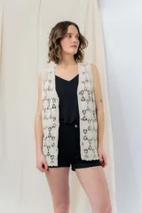 Chaleco tejido calado color crudo con escote en V y cierre frontal con botones.