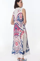 Vestido largo color crema con estampado cachemir en tonos marrones, con cuello camisero, sin mangas y abotonado al frente.