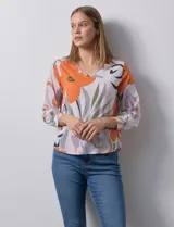 Blusa de gasa estampada con flores naranjas, grises y verdes, de escote en V y manga larga con puño. Marca Sioni.
