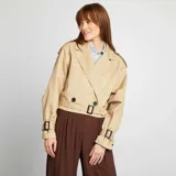 Gabardina corta color beige con cuello solapa, manga larga con trabillas ajustables, cierre cruzado con botón y cinturón.