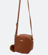 Bolso bandolera pequeño de cuero sintético negro con doble compartimento con cierre de cremallera dorada, asa corta y correa larga ajustable. Incluye pompón decorativo.