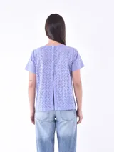 Blusa azul claro con pequeños calados en forma de flor.