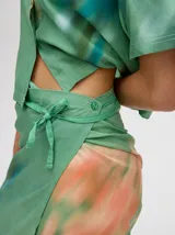 Falda midi marrón con estampado floral en tonos lila, abertura lateral y tiras ajustables.