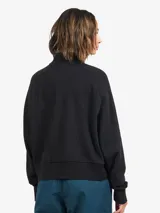 Buzo de cuello alto color negro, confeccionado en algodón, con ajuste holgado y cierre de cremallera frontal.