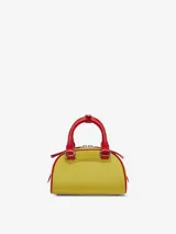 Bolso tipo mini bandolera con forma de domo, color amarillo vibrante con ribetes y asas superiores en rojo. Presenta el logo ovalado 'D' de Diesel en relieve en el frente.