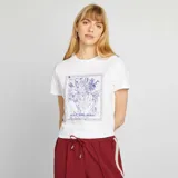 Camiseta blanca de manga corta con estampado de tigre enmarcado en azul y texto "WILD AND REBEL".
