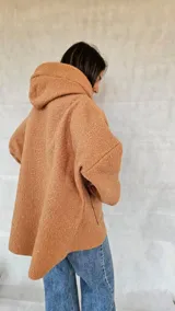 Campera color ocre con capucha y cierre frontal asimétrico.