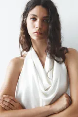 Top negro de satén con cuello halter drapeado ajustable con lazada en el cuello y espalda descubierta con lazada.