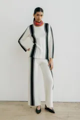 Pantalón de punto color crudo con rayas verticales negras a los costados.