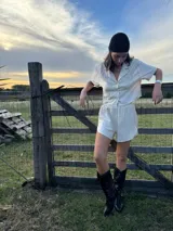 Conjunto de dos piezas color natural, compuesto por una camisa corta de manga corta con cuello y botones frontales, y un short a juego.