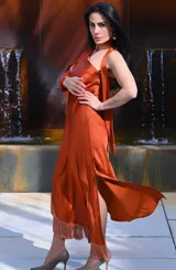 Vestido midi color ocre, con escote halter, lazo al cuello y detalle de flecos en el ruedo.