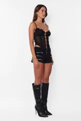 Microshort negro de gabardina elastizada con cierre metálico a la vista en la cartera y bolsillos traseros. En los laterales delanteros presenta cierres metálicos decorativos.