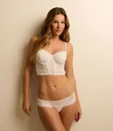 Corset blanco de encaje floral sin copa, con tirantes ajustables y cierre trasero.
