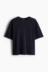 Conjunto de pijama corto de dos piezas. Remera negra de punto de algodón liviano con cuello redondo ribeteado acanalado, hombros caídos y bajo recto. Short negro en popelina de algodón con elástico revestido en la cintura, cierre de botón, bolsillos laterales y un bolsillo parche atrás.