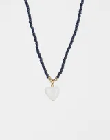 Collar corto de mostacillas azul marino con dije de corazón blanco y detalles dorados.