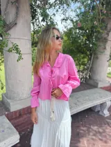 Camisa rosa de lino, de corte crop y mangas largas con puños elásticos.