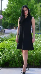Vestido corto negro, sin mangas y corte evasé.