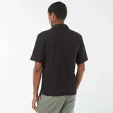 Camisa negra de manga corta con cuello solapa y cierre frontal con botones de madera.