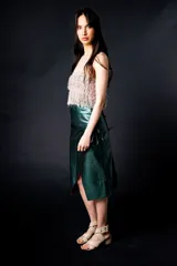 Falda midi de cuero color marrón, de corte recto y estilo portafolio. Se ata en los costados con tiritas.