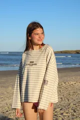 Buzo de manga larga reversible. Un lado es color arena con rayas horizontales marrones y el otro lado es azul marino liso.