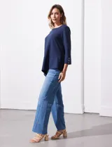 Blusa en tejido acanalado, marca Ruby Rd. Largo de mangas ¾ con abertura y botones. Terminación de ruedo asimétrico.