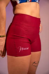 Calza corta deportiva color borgoña, de tiro alto y con logo estampado en la pierna izquierda.