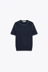 Top de punto color crema, de cuello redondo y manga corta con detalle de vivos a contraste en cuello y hombros.