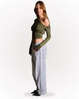 Top manga larga color verde militar, con escote asimétrico y hombro descubierto.