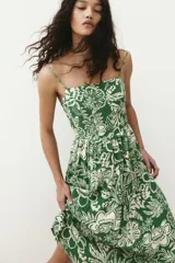 Vestido midi verde con estampado floral blanco, breteles finos ajustables, escote cuadrado, espalda fruncida y falda con vuelo.