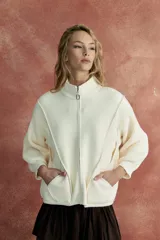 Saco campera color blanco con cierre frontal, cuello alto y bolsillos laterales.