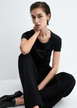 Remera negra de algodón con cuello redondo y logo de la marca estampado en el pecho.