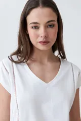 Remera color durazno con escote en V y detalle de vainillas en los laterales. De manga corta y corte recto.