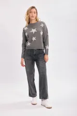 Sweater gris con estrellas blancas de punto intarsia, cuello redondo y mangas largas.