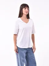 Remera blanca de corte holgado con cuello en V y mangas cortas.