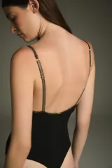 Body negro con escote en V y breteles finos con detalles dorados.