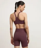 Bermuda deportiva femenina de microfibra color ciruela, corte ajustado y largo tipo ciclista, con bolsillos laterales. Confeccionada con poliamida y elastano.