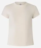 Remera color crema de corte ajustado y largo, confeccionada en tejido de punto acanalado.