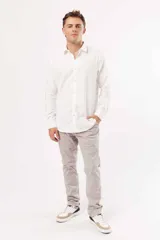 Camisa blanca de corte slim fit, manga larga y cuello clásico. Cierre frontal con botones.