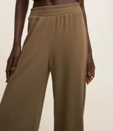 Pantalón largo marrón de corte recto, confeccionado en tejido de punto acanalado con cintura elástica ancha y superficie texturizada.