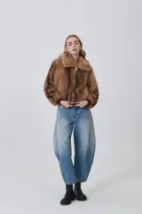 Campera de piel sintética color tostado con cuello clásico, cierre frontal de cremallera y terminaciones elásticas en puños y cintura.