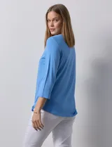 Remera celeste de modal con cuello cuadrado y apliques de aros metálicos.